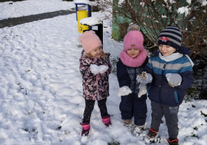 Troje dzieci ze śniegiem w rękach